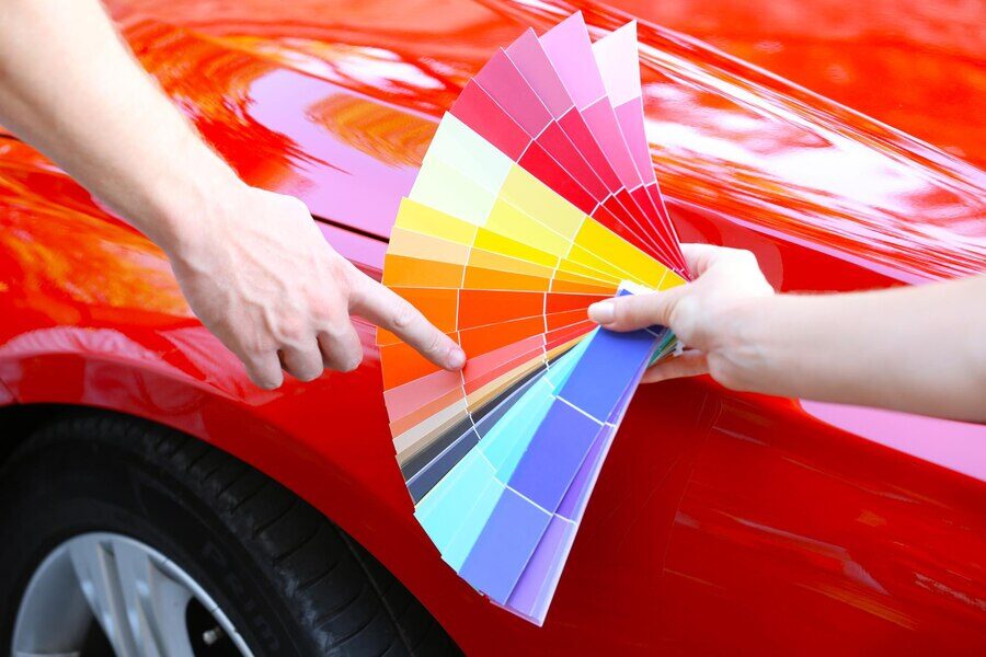 Auto technician showing paint color shades to client