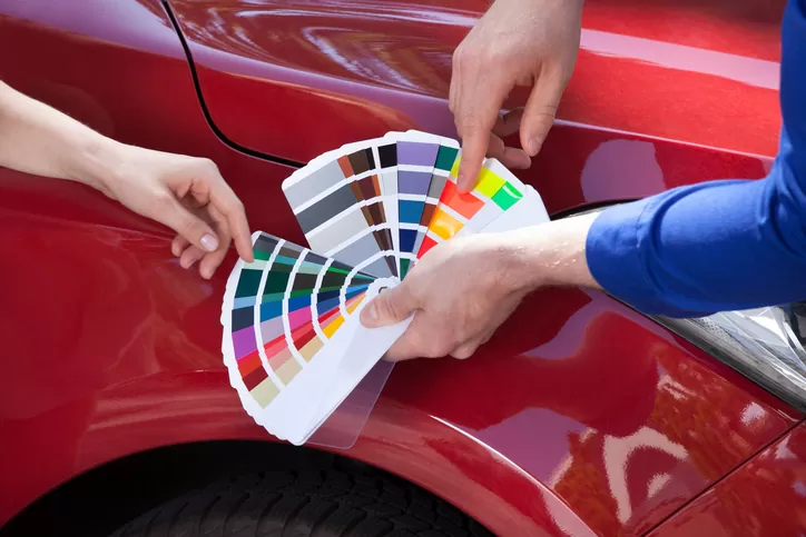 Mechanic showing car paint color shades to a client