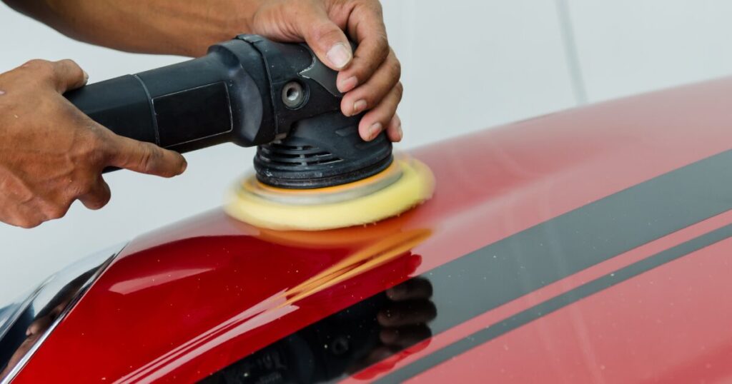 Technician buffing a red car