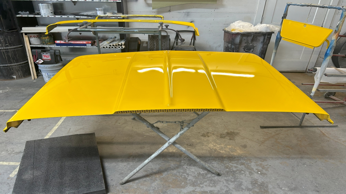 Newly painted hood of yellow off road truck