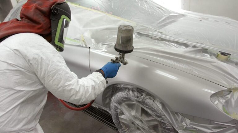 Technician painting a car