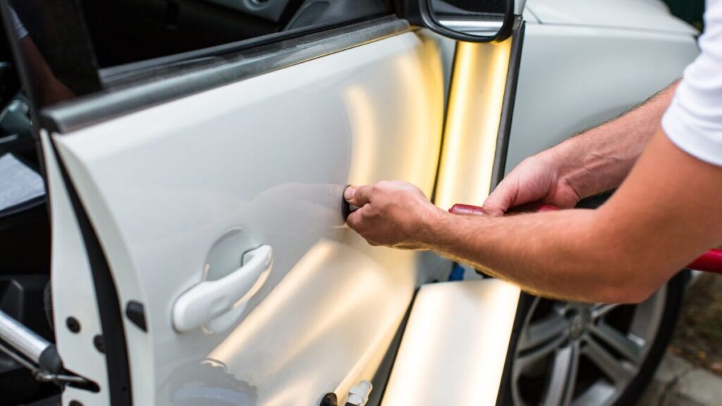 Technician repairing a car dent