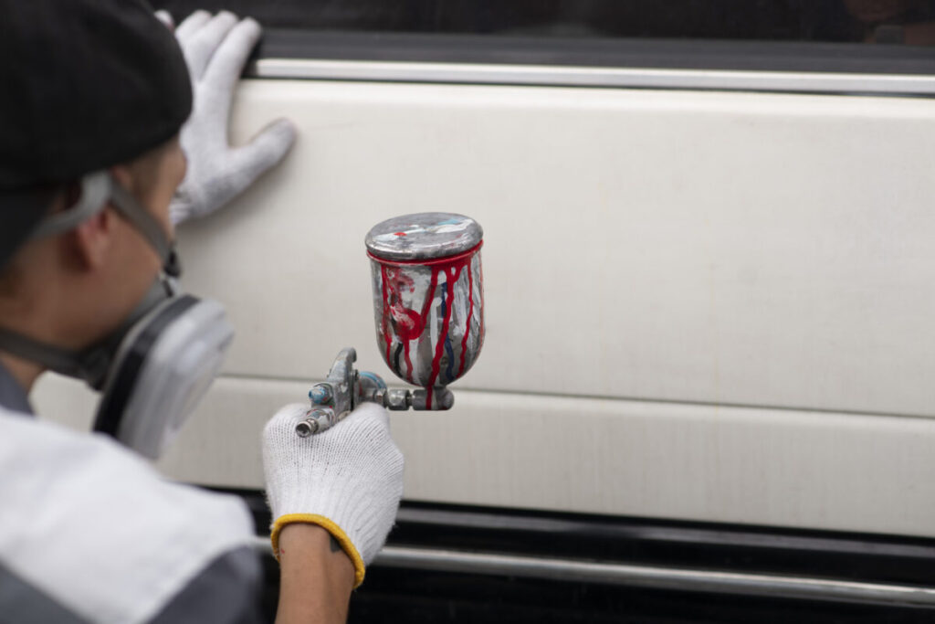 Man spraying powder paint to a car